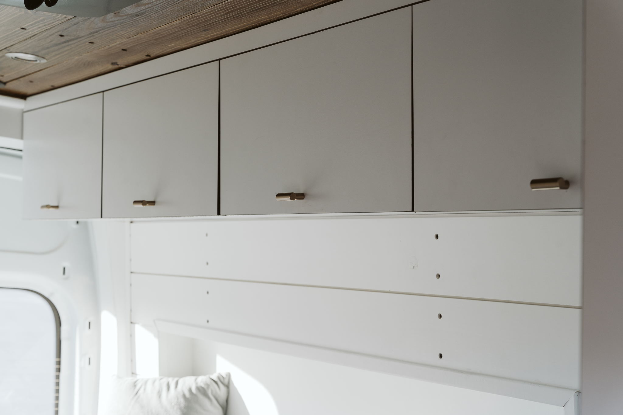 This Professional Conversion Is Perfect For Vanlife In USA | Everest Conversions 8 white ceiling cabinets vanlife