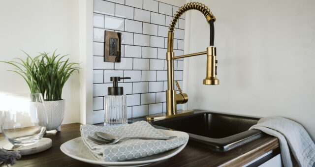 vanlife kitchen sink with gold taps and wood sideboard